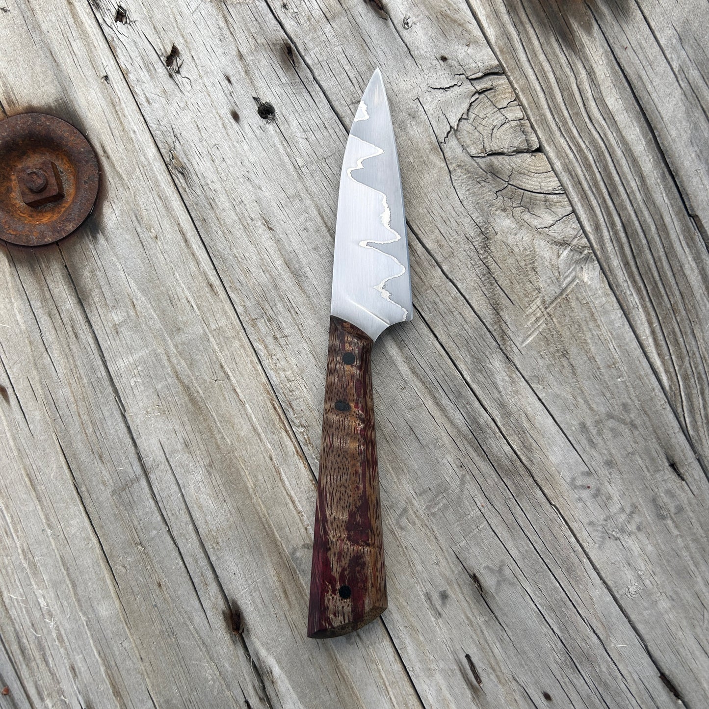 Beautiful Japanese styled paring knife with a two tone blade and red and tan wood handle
