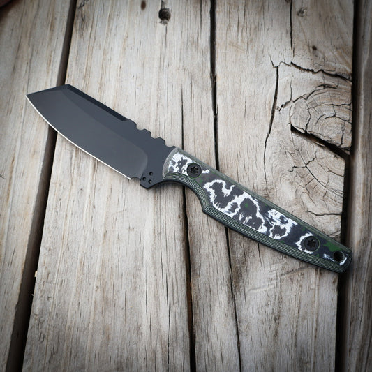 Black knife with white green handle on wooden surface