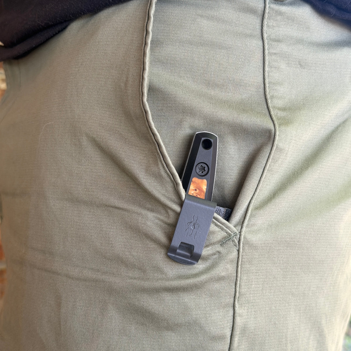 Knife sheath in pants pocket with clip Exposed and knife handle protruding about and inch and a half out of pocket.