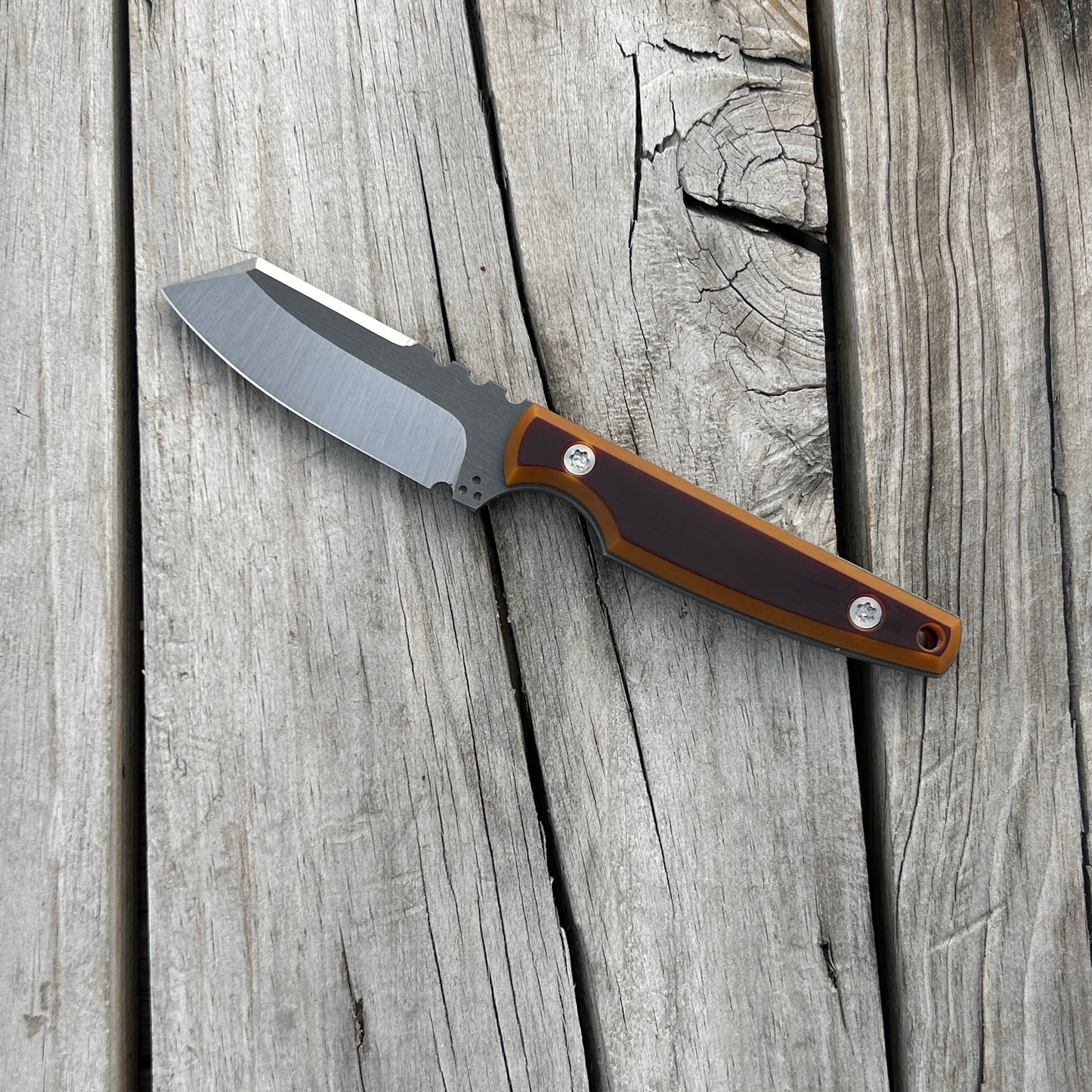 Knife with brown and butterscotch handle sitting on wooden surface