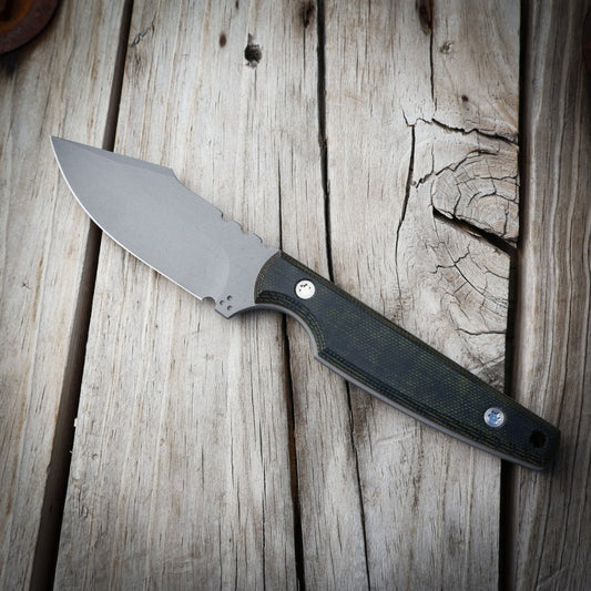 Knife with a black & green handle on a wooden surface