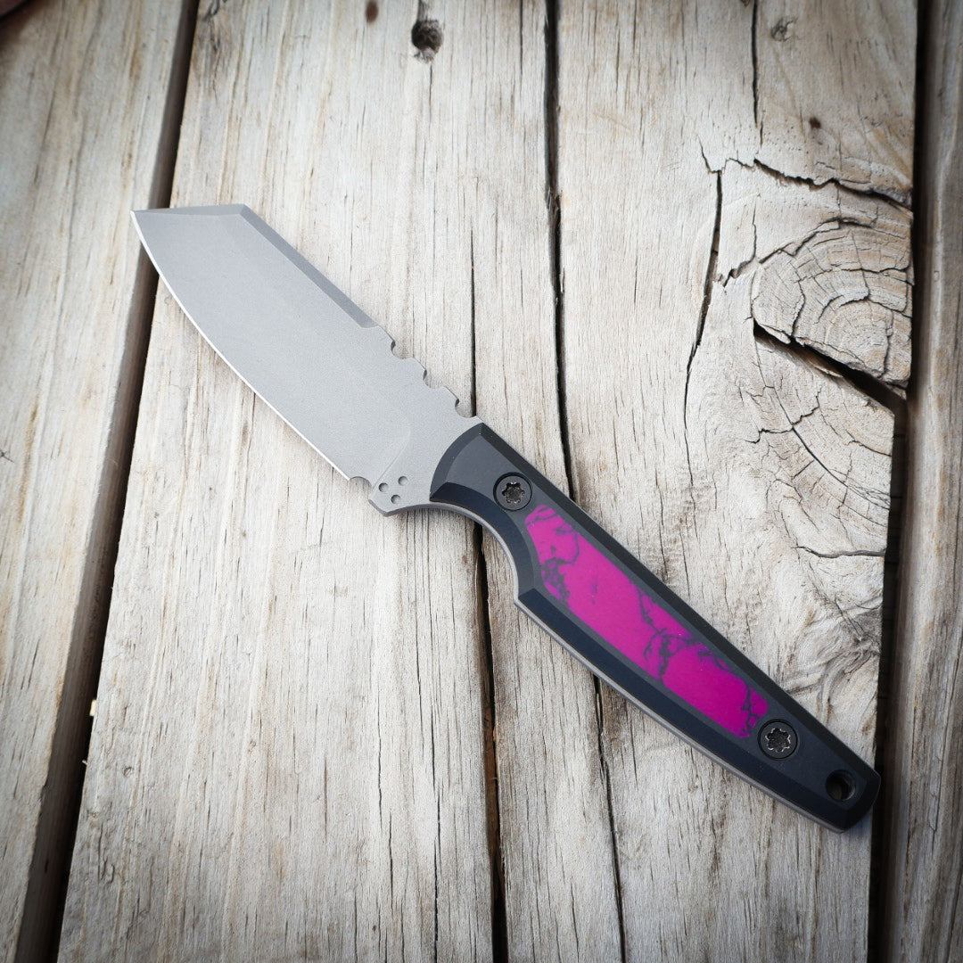 Knife with a purple handle on a wooden surface