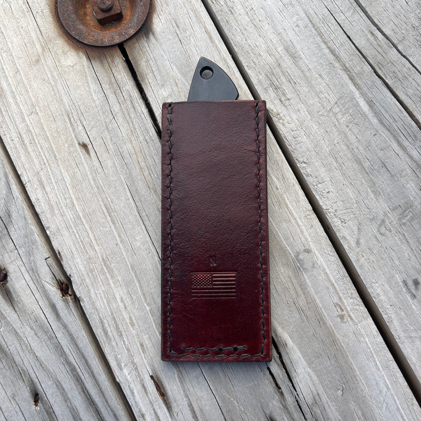 knife in leather pocket slip with stamp of American flag and "N" on it