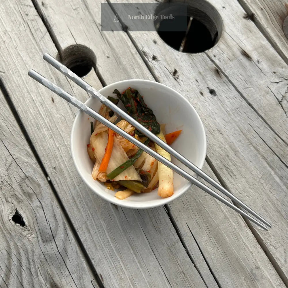 stainless steel chopsticks with bowl of kimchi