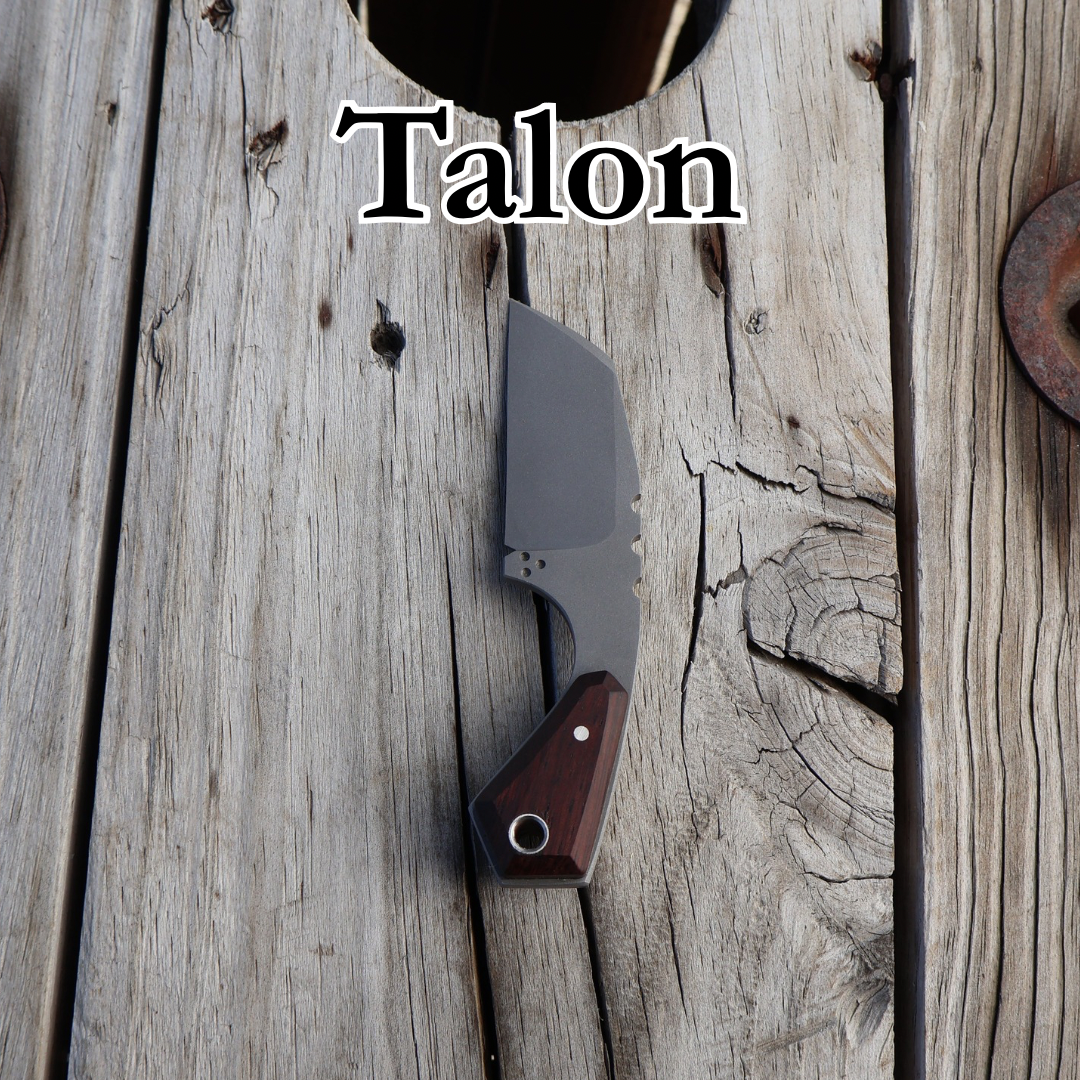 Small wharncliff neck knife with tan handle sitting on wooden surface with text “Talon” above it 