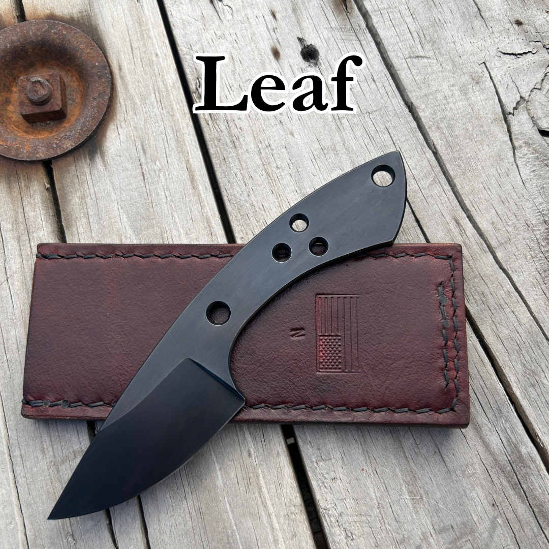 Small skeletonized blade sitting on leather slip on wooden surface with text “Leaf” above it