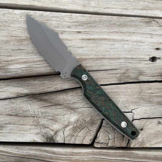 A fixed-blade knife with a matte gray blade and a green marbled handle with copper-brown swirls, resting diagonally on weathered gray wooden planks.