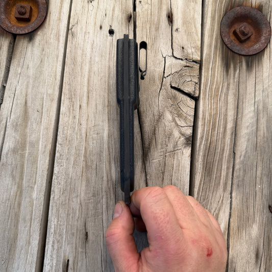 Side profile of deep pocket kydex knife sheath with hand holding it in position sitting on wooden surface 