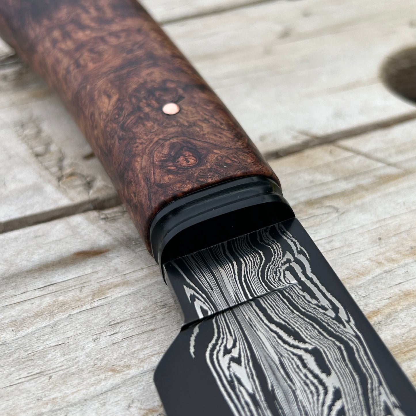 closeup of damscus blade and black fluted bolster