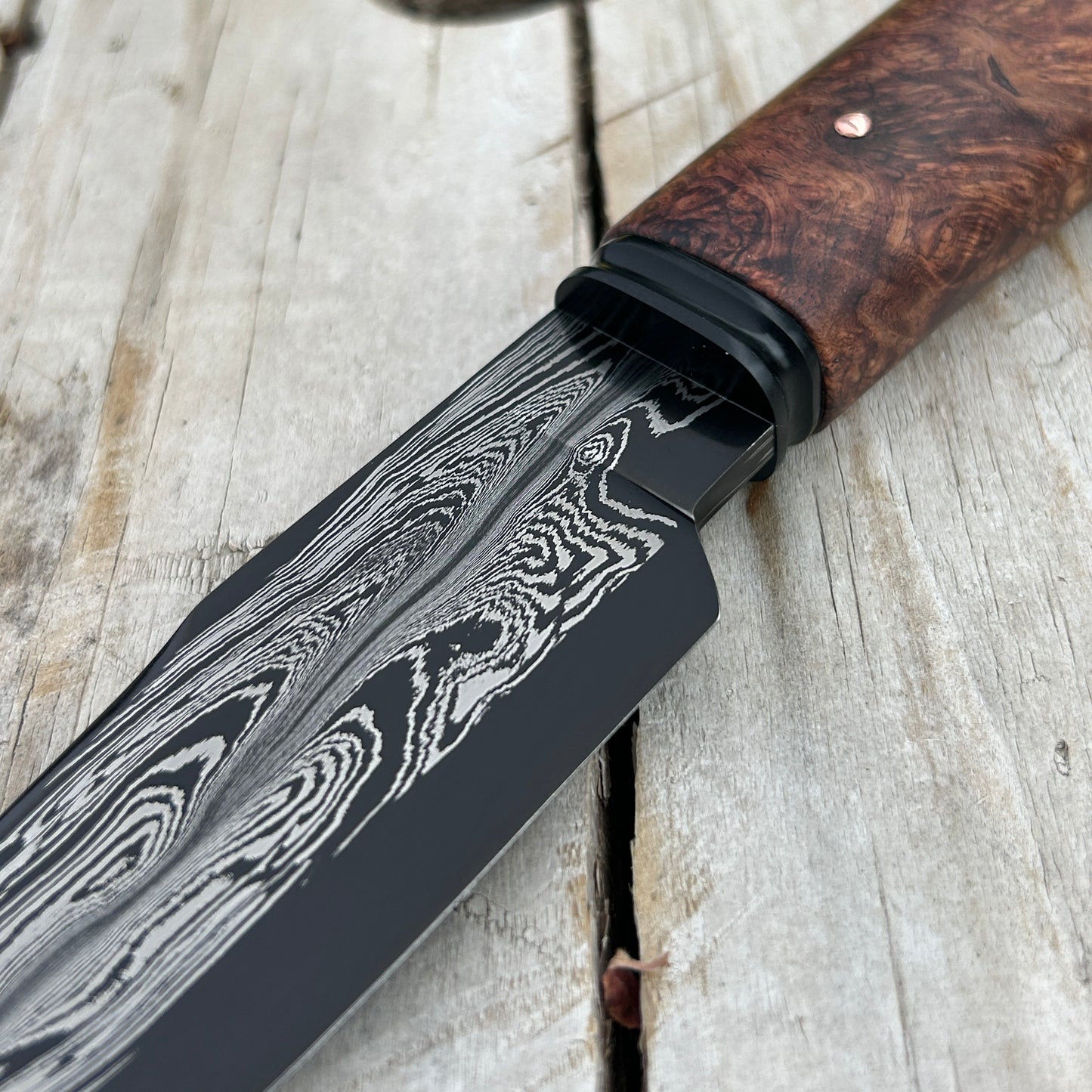 closeup of damscus blade and black fluted bolster