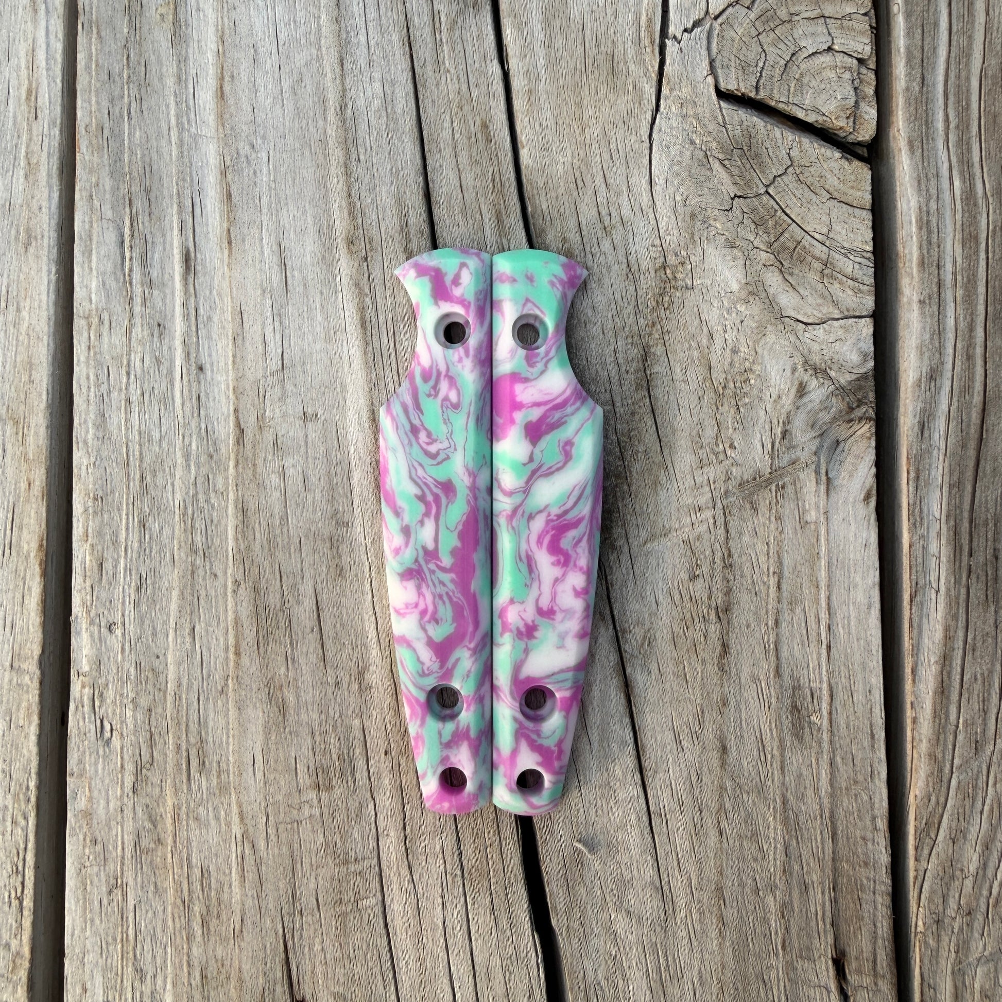 Colorful knife handle scales sitting on wooden surface 