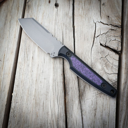 Knife with a purple handle on a wooden surface