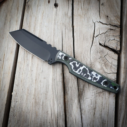 Black knife with white green handle on wooden surface