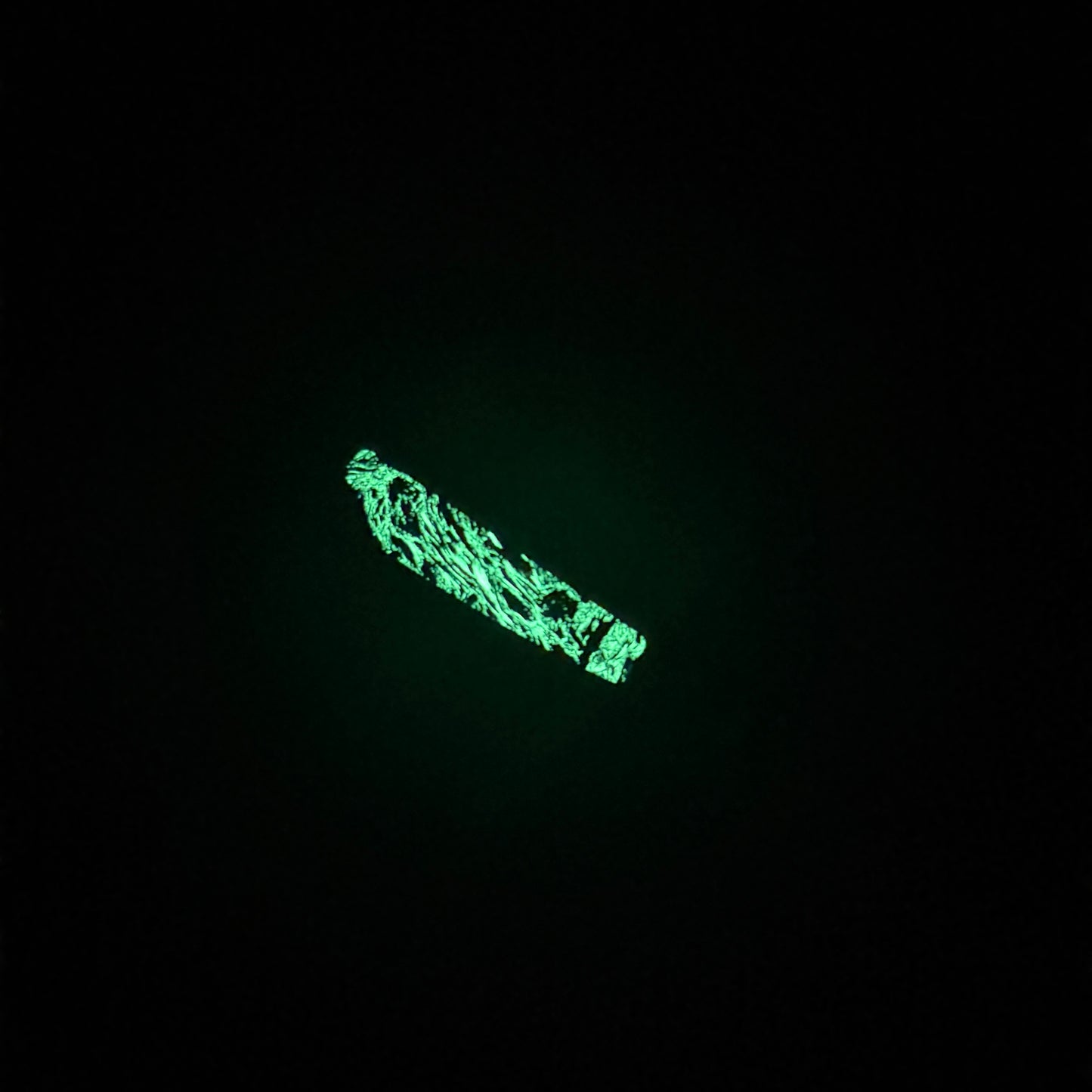 Glow in the dark inlay on knife handle. Glowing green with specs of black in the middle 