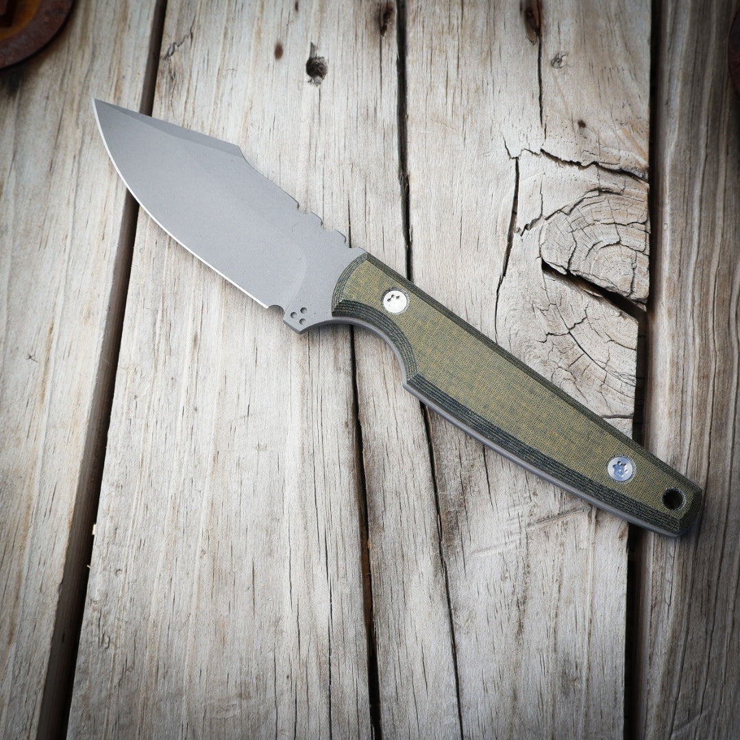 knife with green handle on wooden surface
