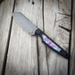 Knife with a colorful handle on a wooden surface