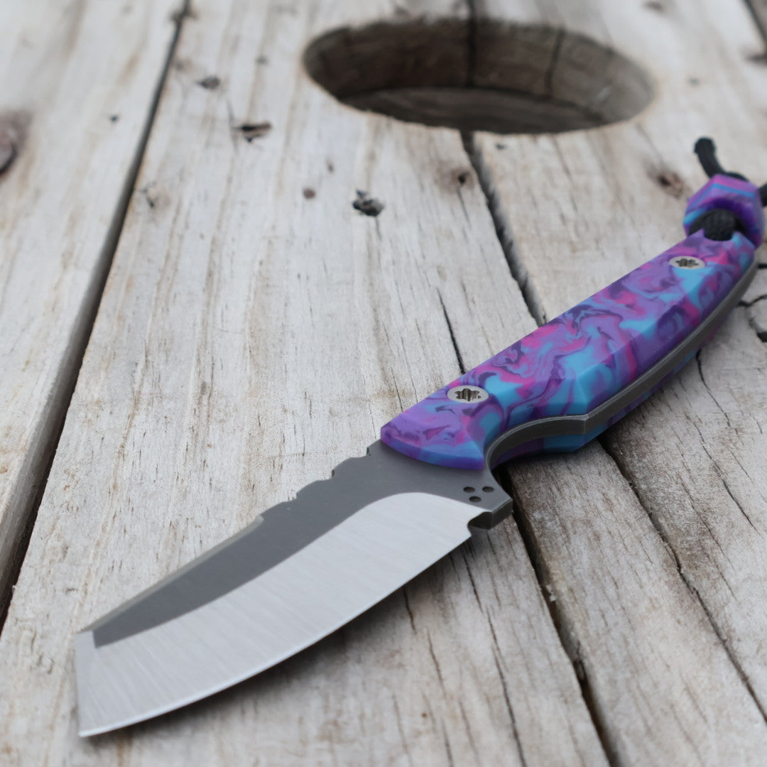 Fixed blade knife with colorful handle on wooden surface
