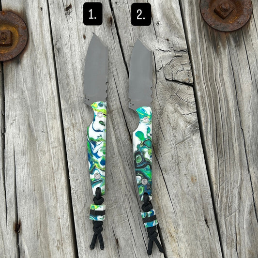 Two knives with colorful handles on a wooden surface