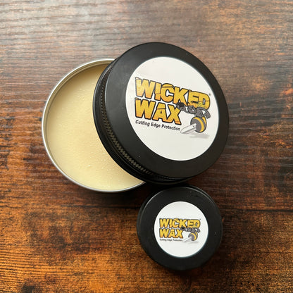 two Wicked Wax cans sitting on wooden surface 