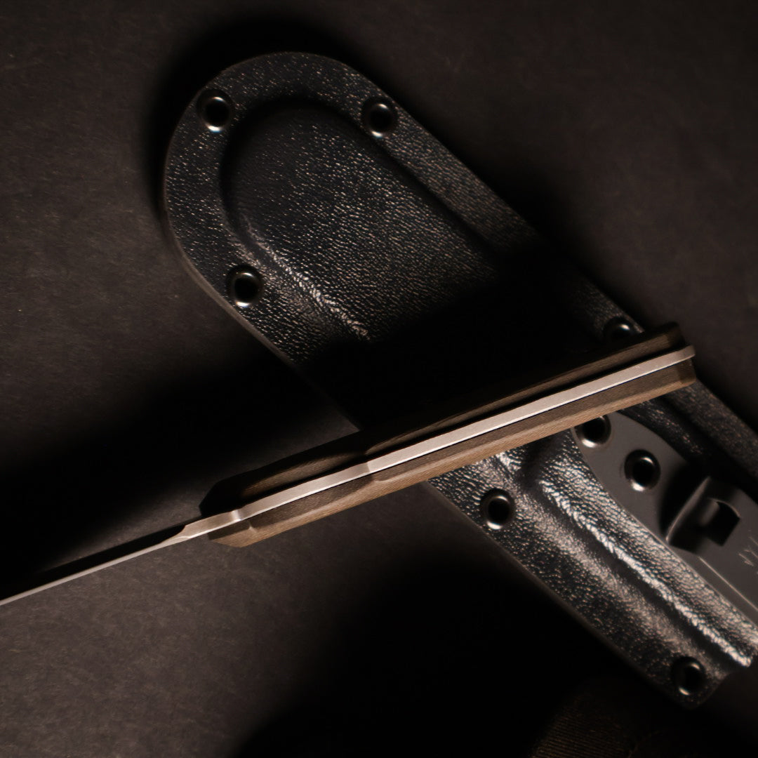 top down shot of knife handle that is propped against a kydex sheath