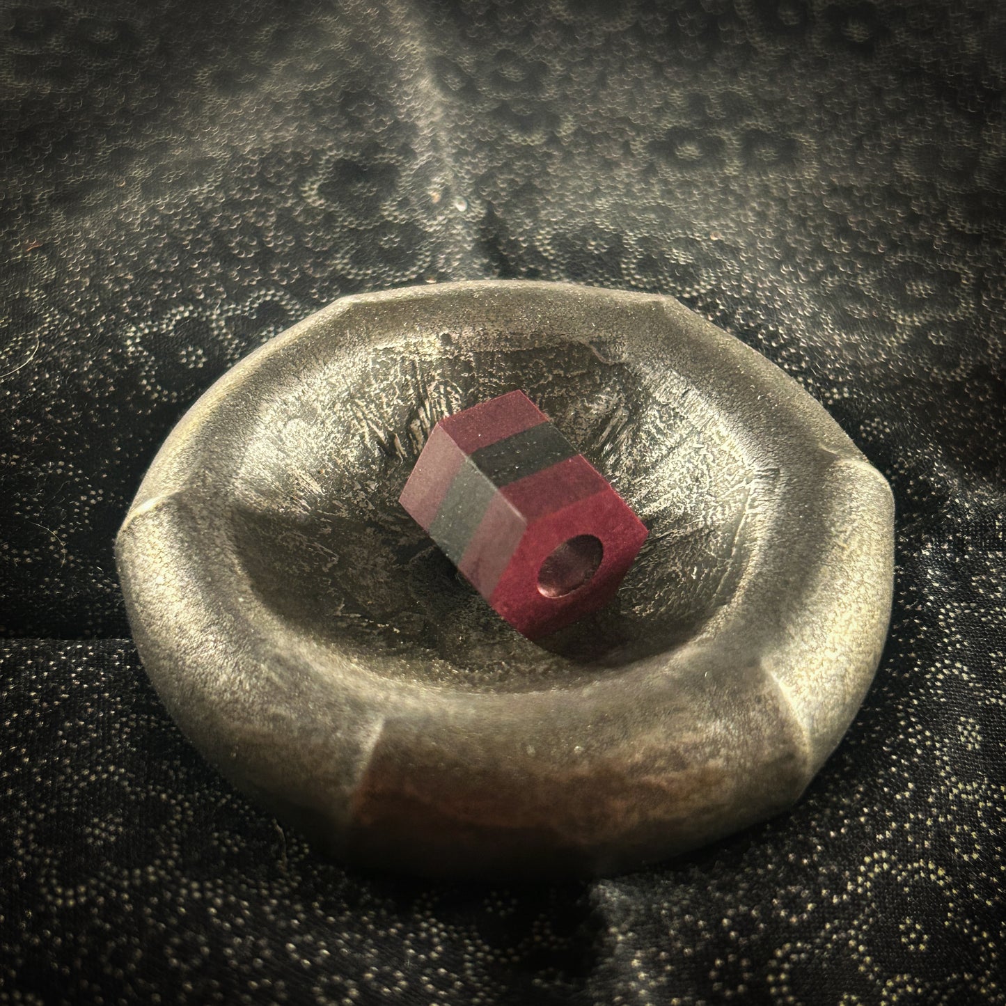 Maroon & black hexagonal lanyard bead in metal dish 