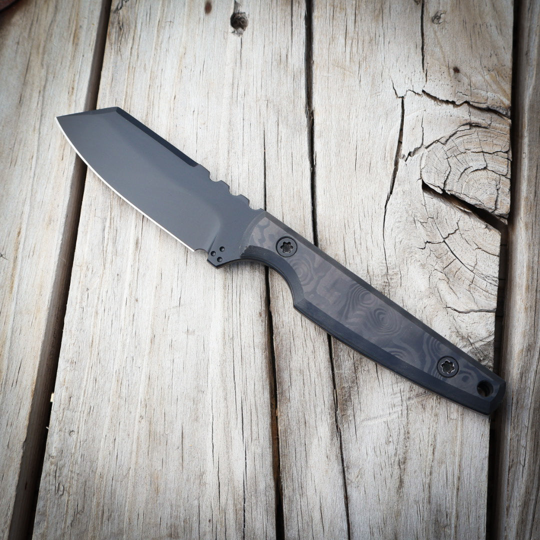 Knife with black blade and black handle on wooden surface 