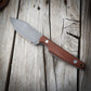 Knife with a brown handle on a wooden surface