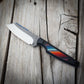 knife with a colorful handle on a wooden background
