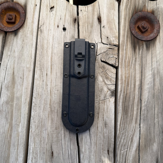 Black deep pocket kydex knife sheath with dark gray clip sitting on wooden surface 