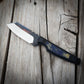Knife with black and blue handle sitting on wooden surface