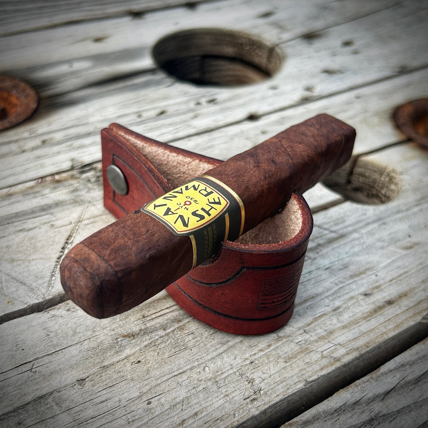 Leather cigar stand with cigar sitting on it