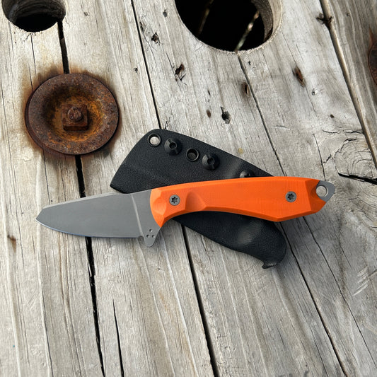 Sheepsfoot style knife with orange handle scales 