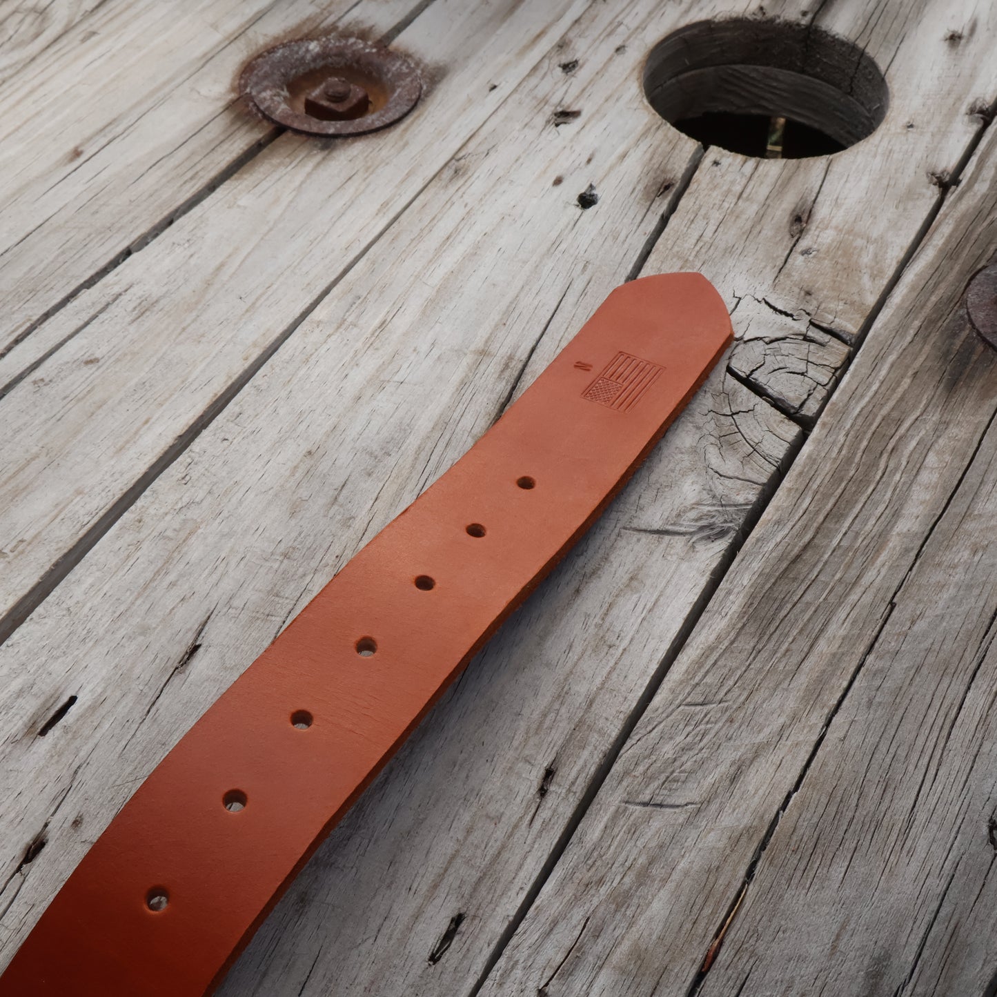 Brown leather belt on a wooden surface
