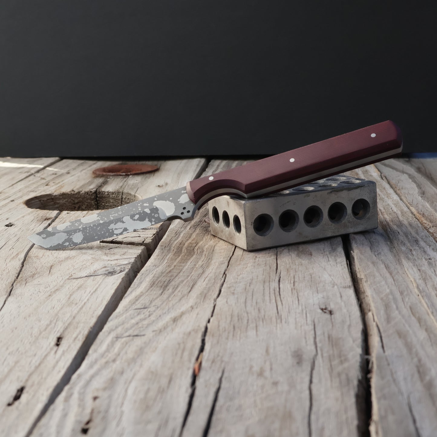 Knife with a burgundy handle on a wooden surface