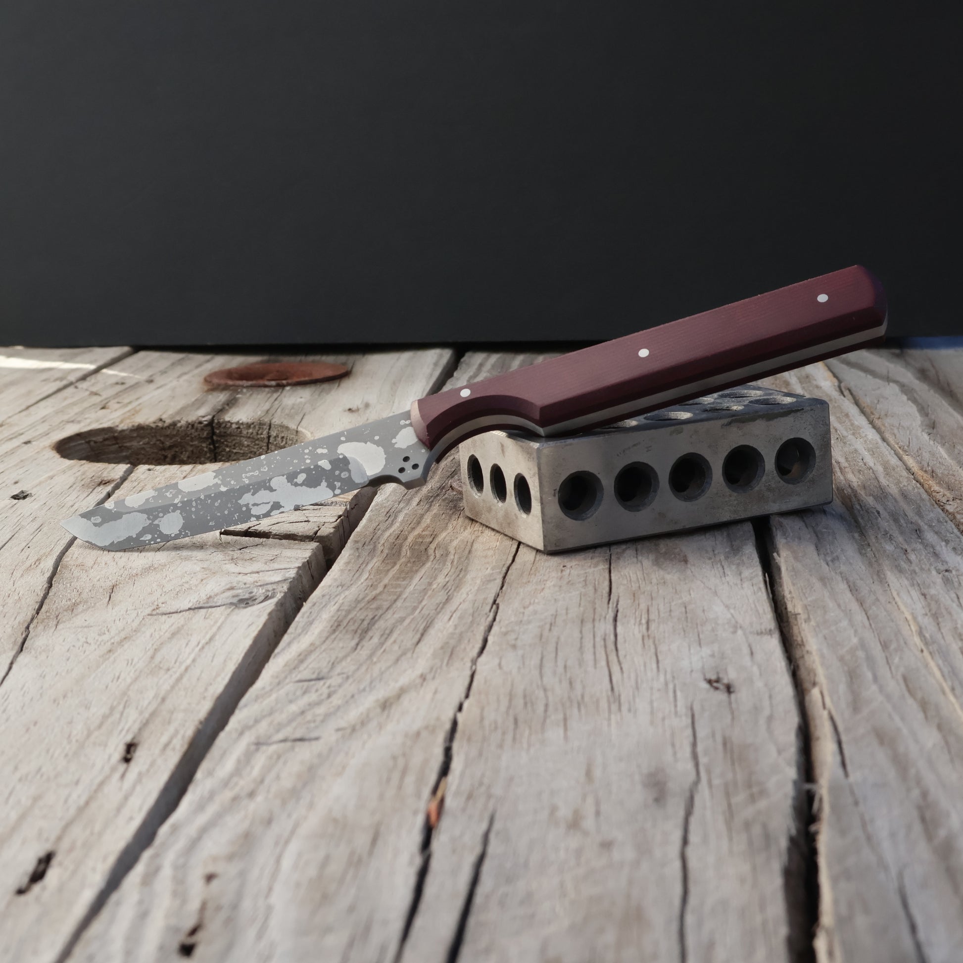 Knife with a burgundy handle on a wooden surface