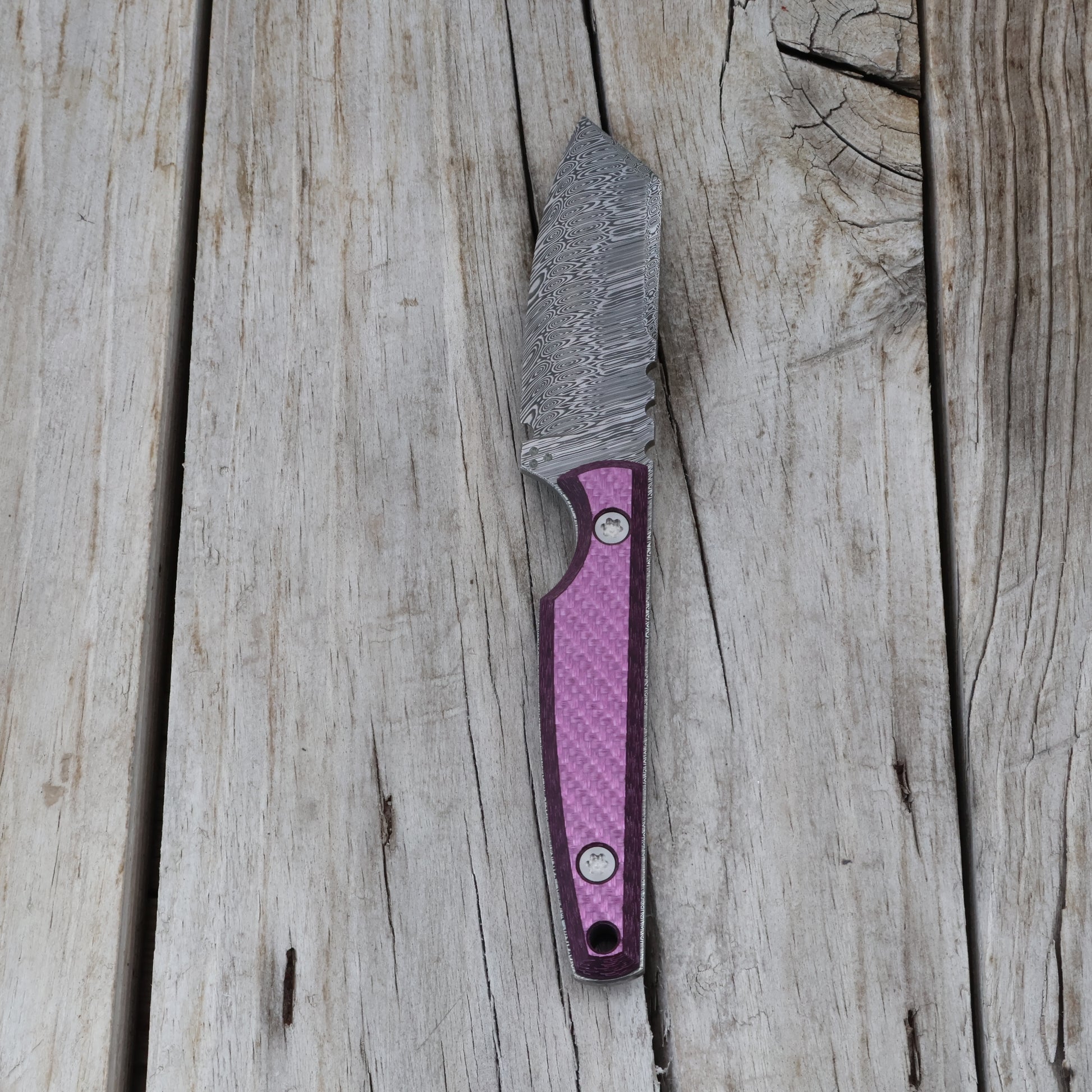 decorative knife with a purple handle on a wooden surface