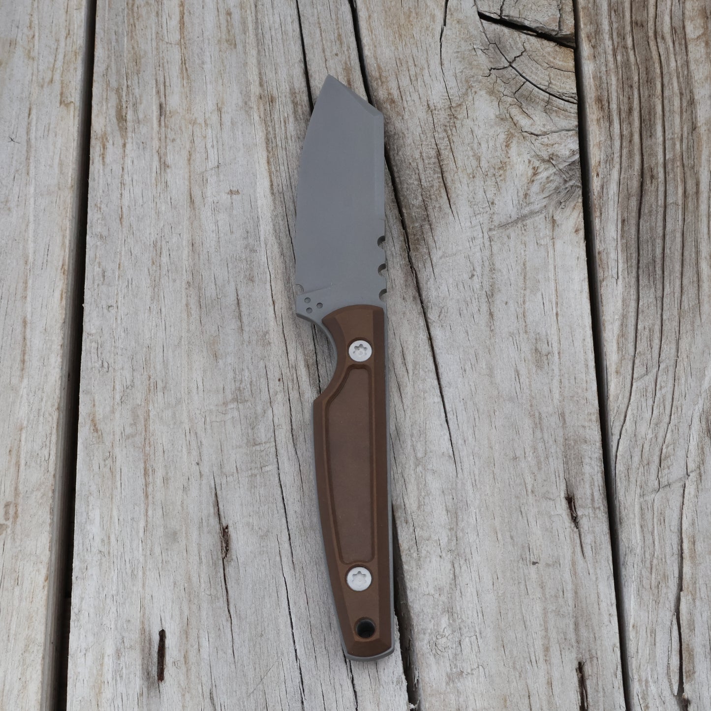knife with a brown handle on a wooden surface