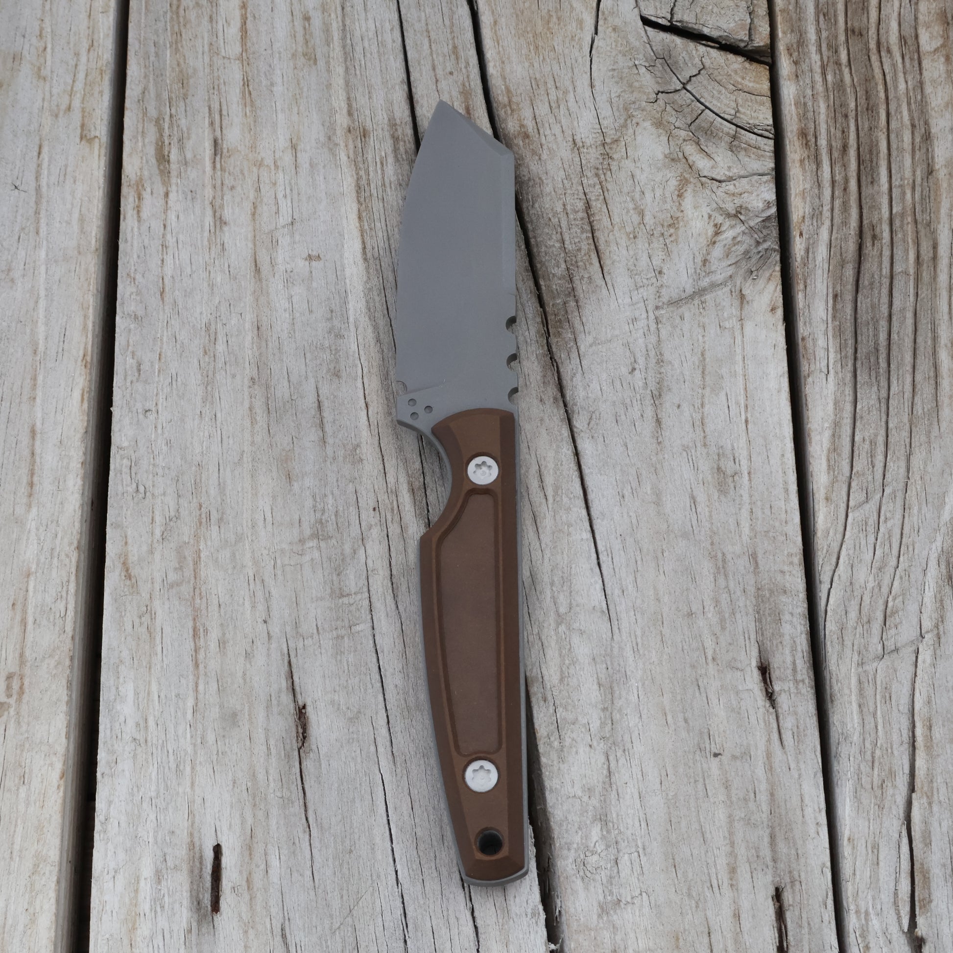 knife with a brown handle on a wooden surface