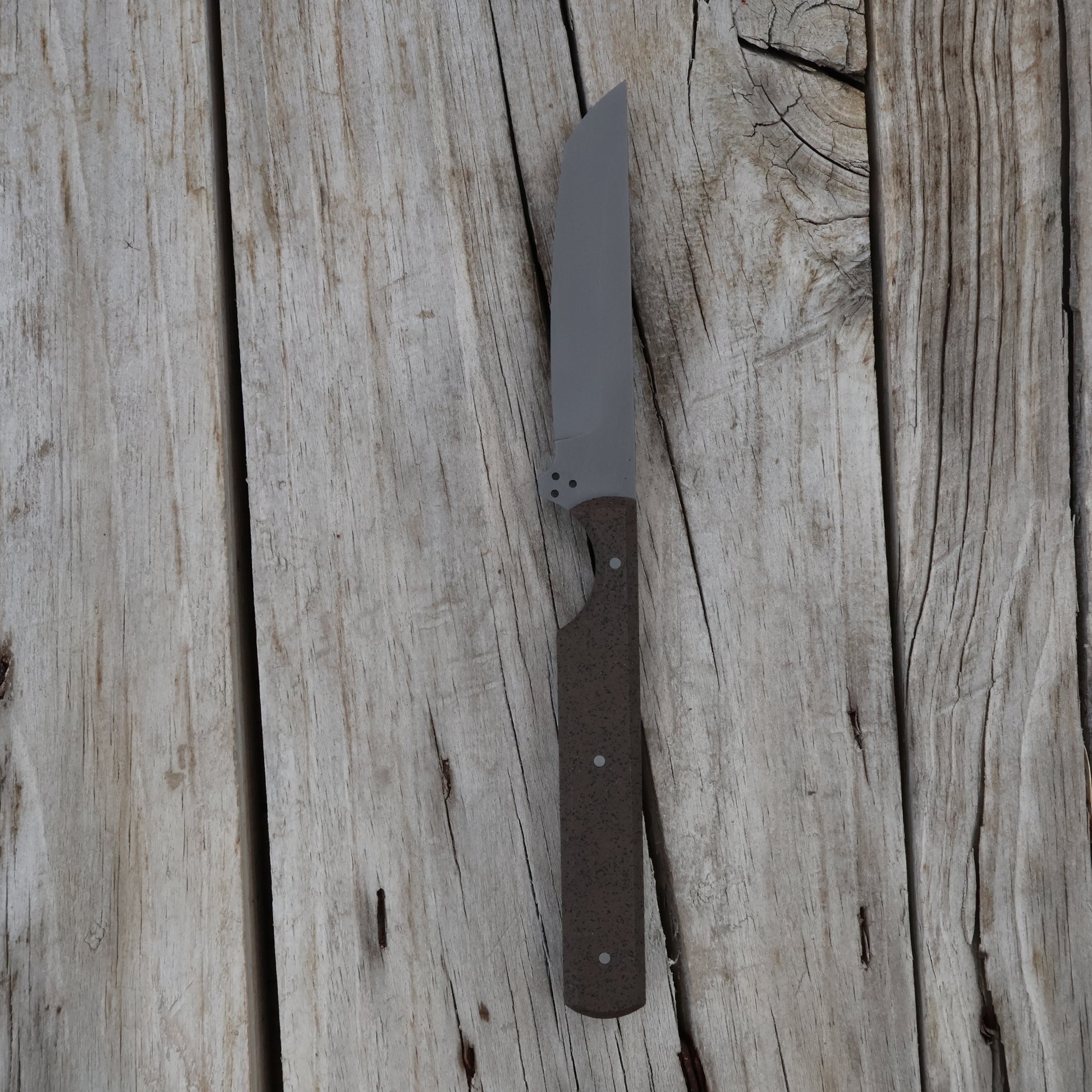 Knife with a brown handle on a wooden surface