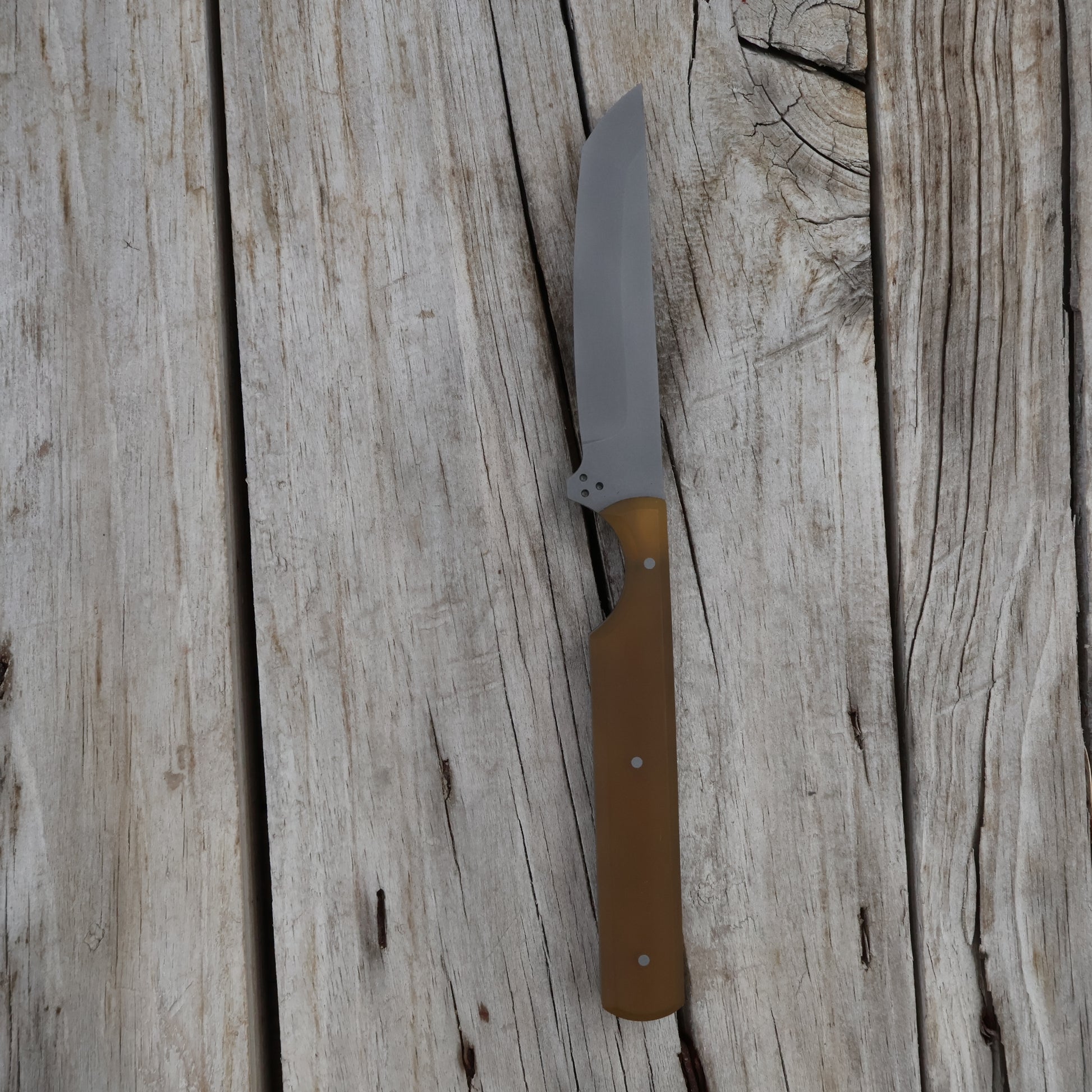 Knife with a brown handle on a wooden surface