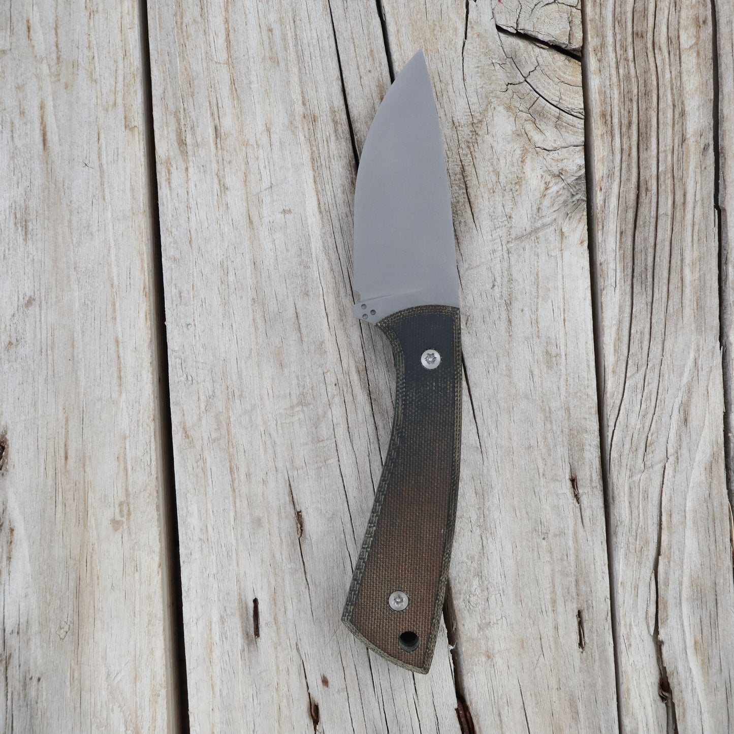  knife with a black/brown handle on a wooden surface