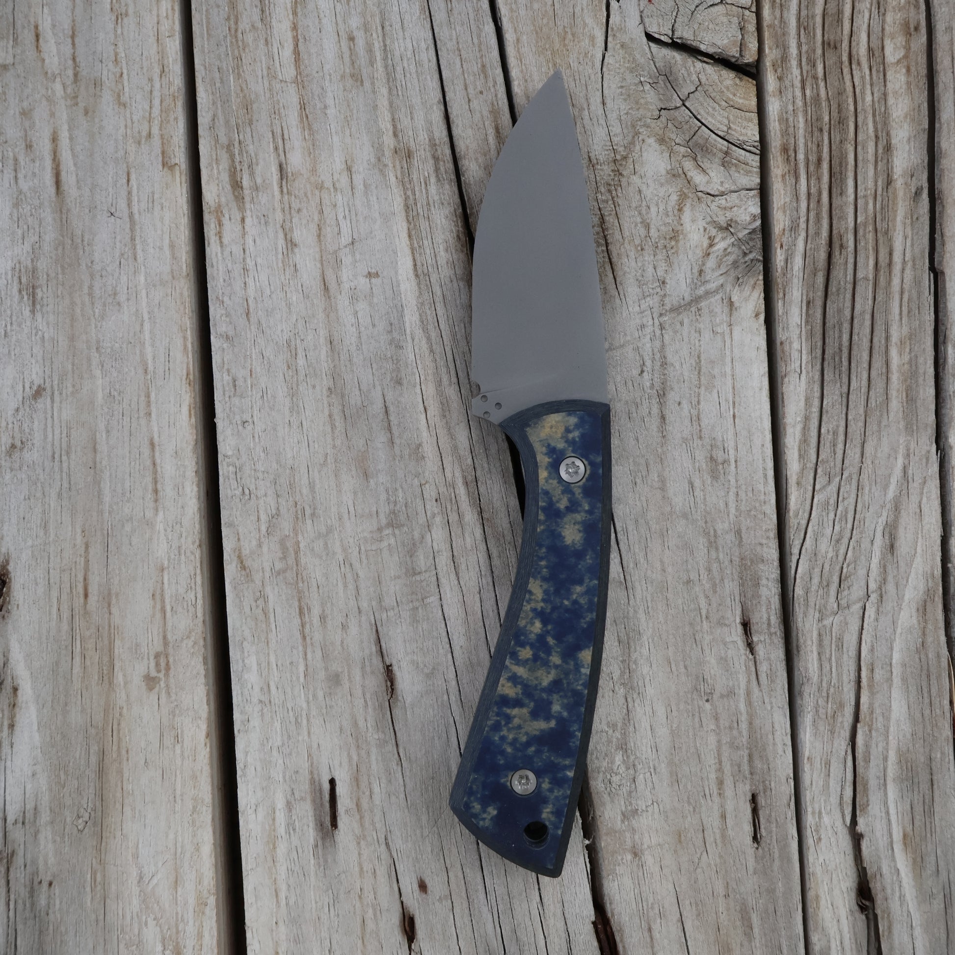 Knife with a blue handle on a wooden surface