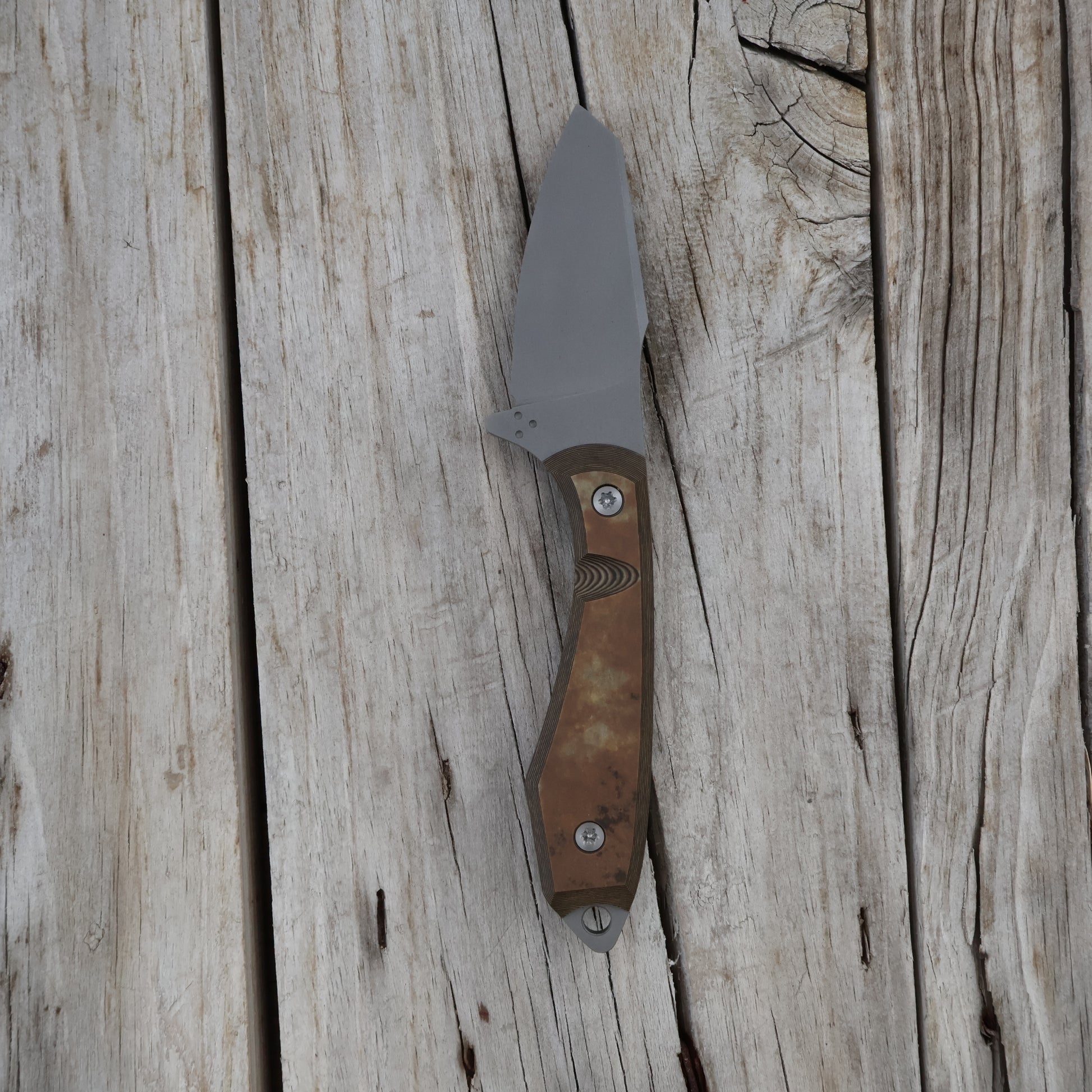 knife with a brown handle on a wooden surface