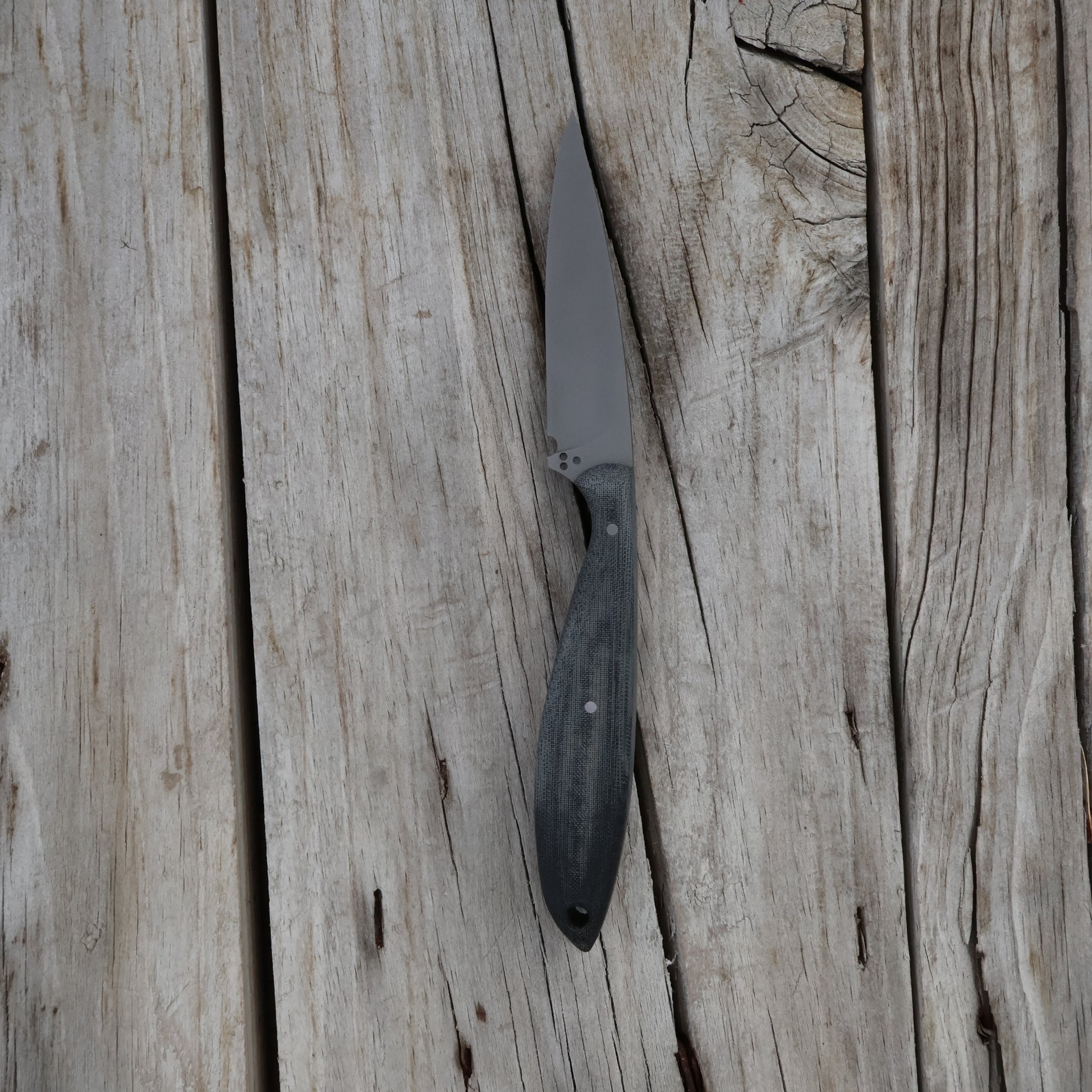 Knife with a black handle on a wooden surface