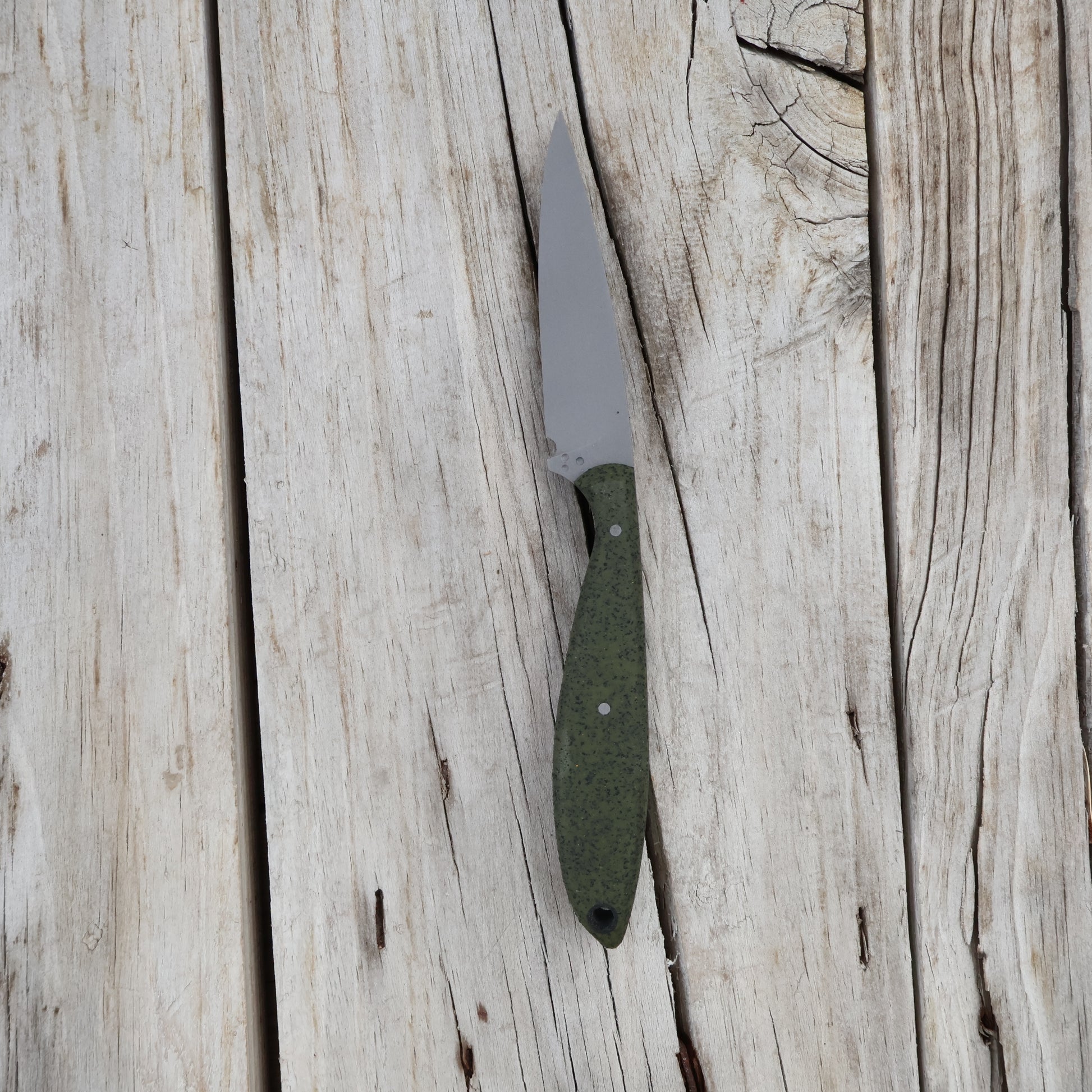 Knife with a green handle on a wooden surface