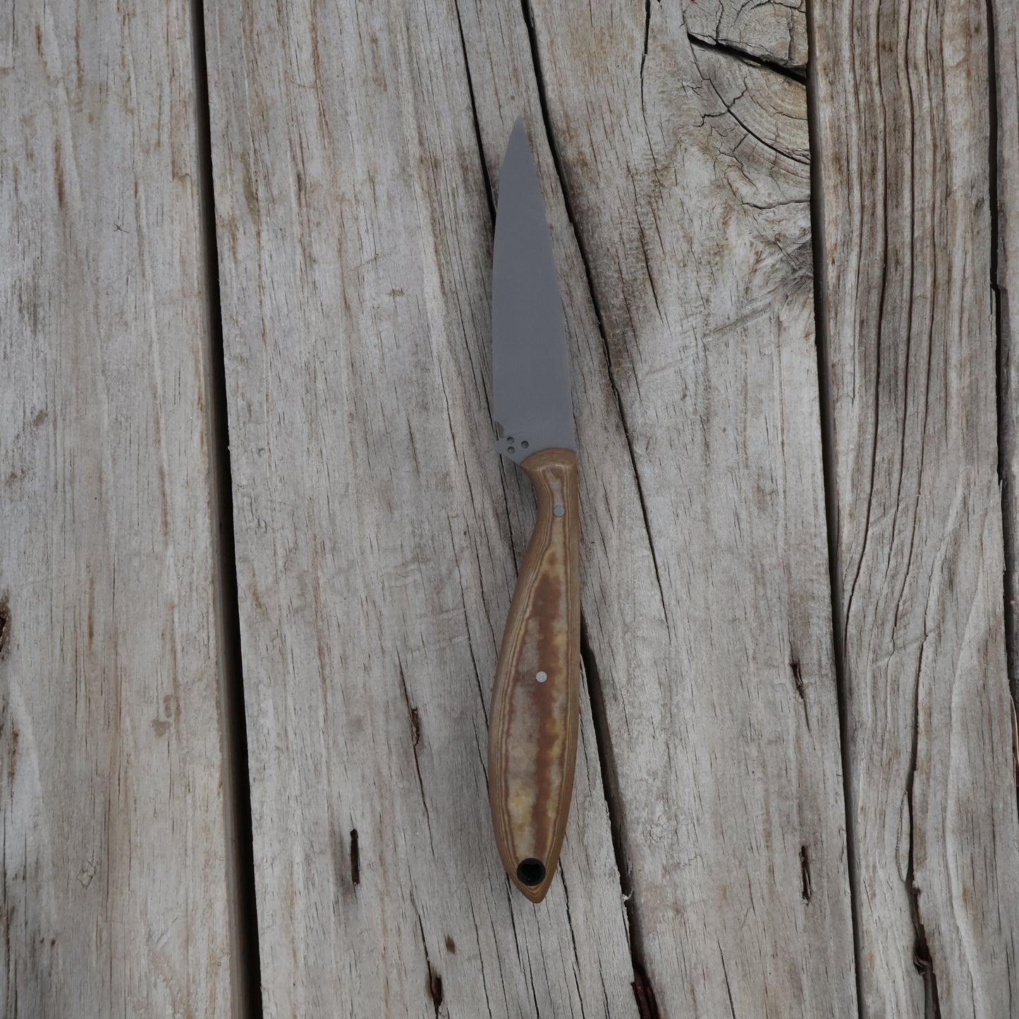 Knife with a light brown handle on a wooden surface
