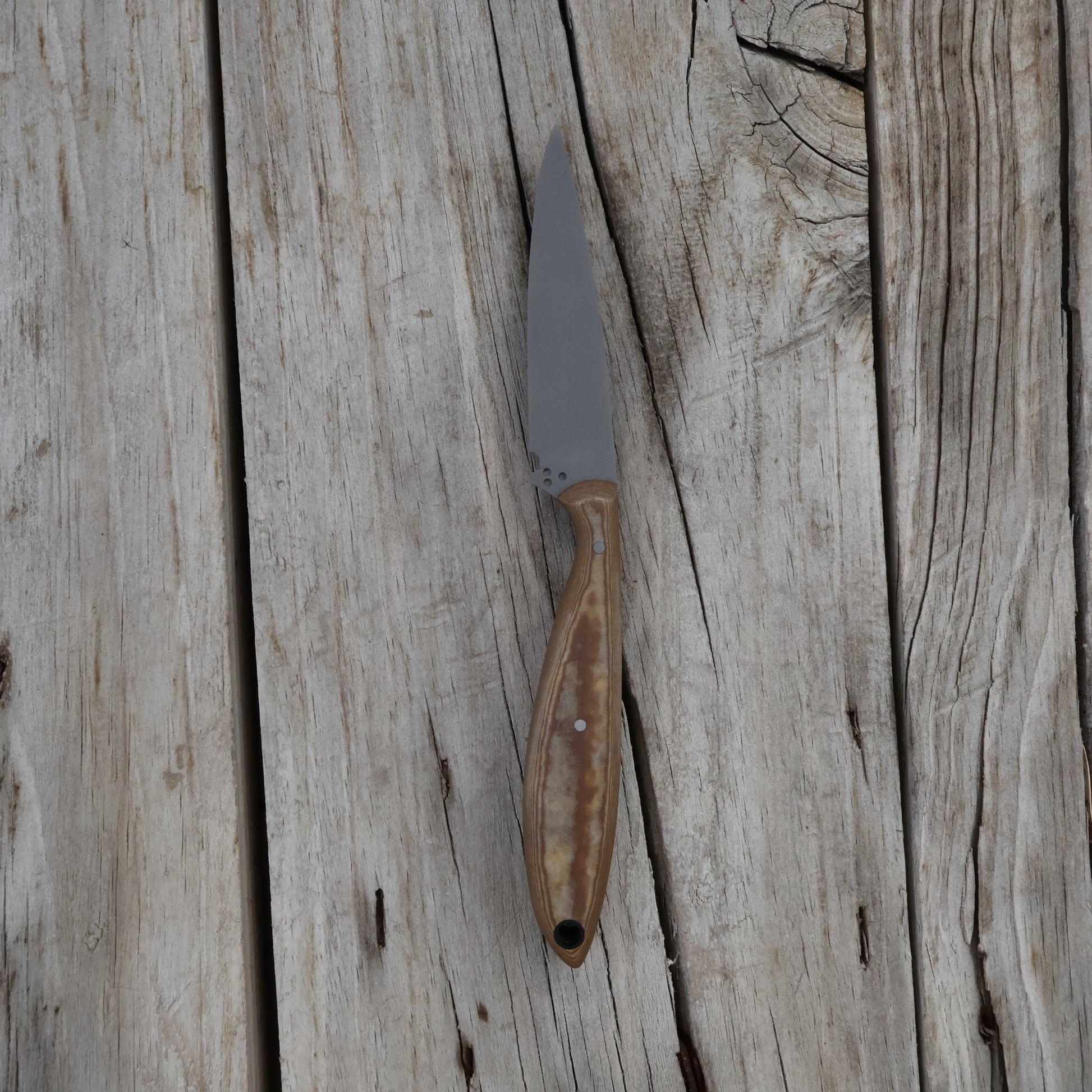 Knife with a light brown handle on a wooden surface