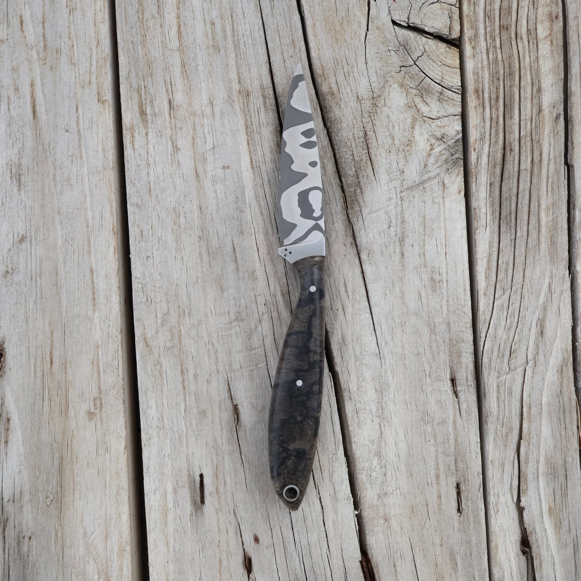 Fishing knife with damascus blade on a wooden surface