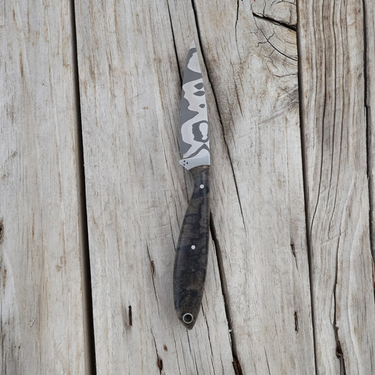 Fishing knife with damascus blade on a wooden surface