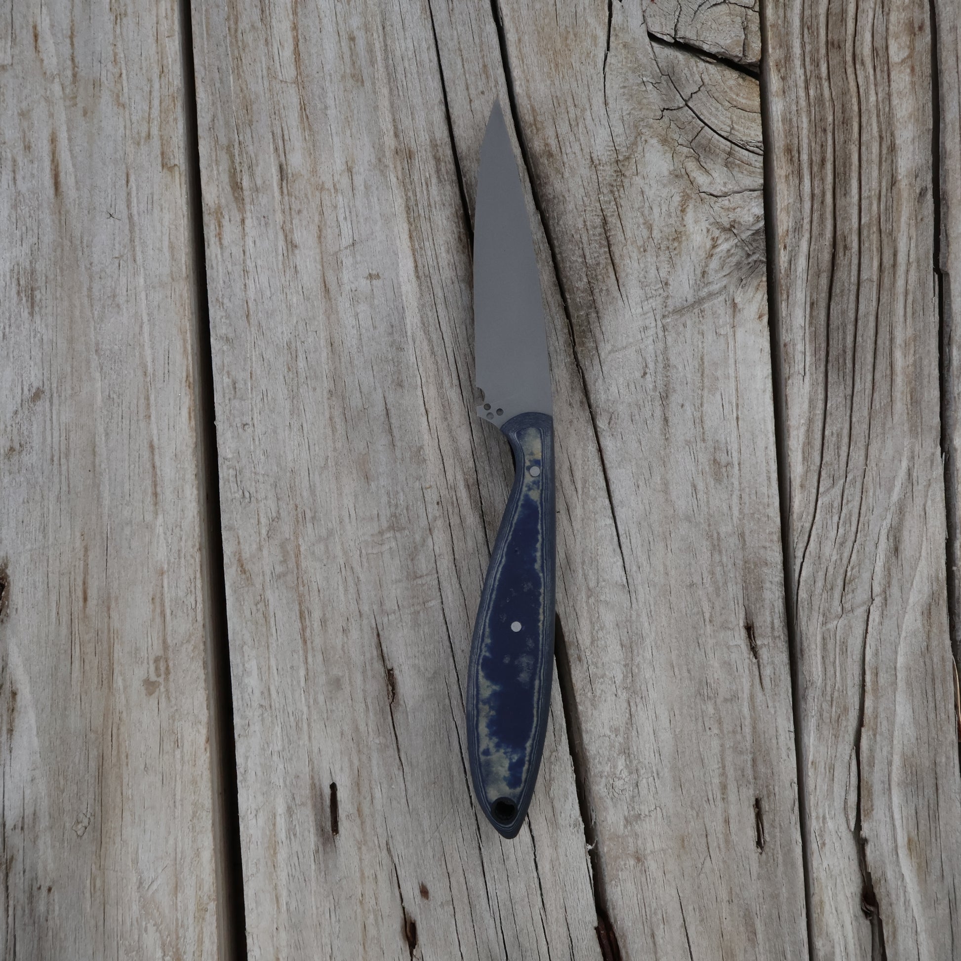 Knife with a blue handle on a wooden surface